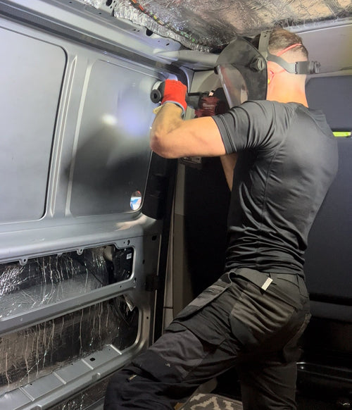 Vanbitious technician carrying out professional work inside a campervan